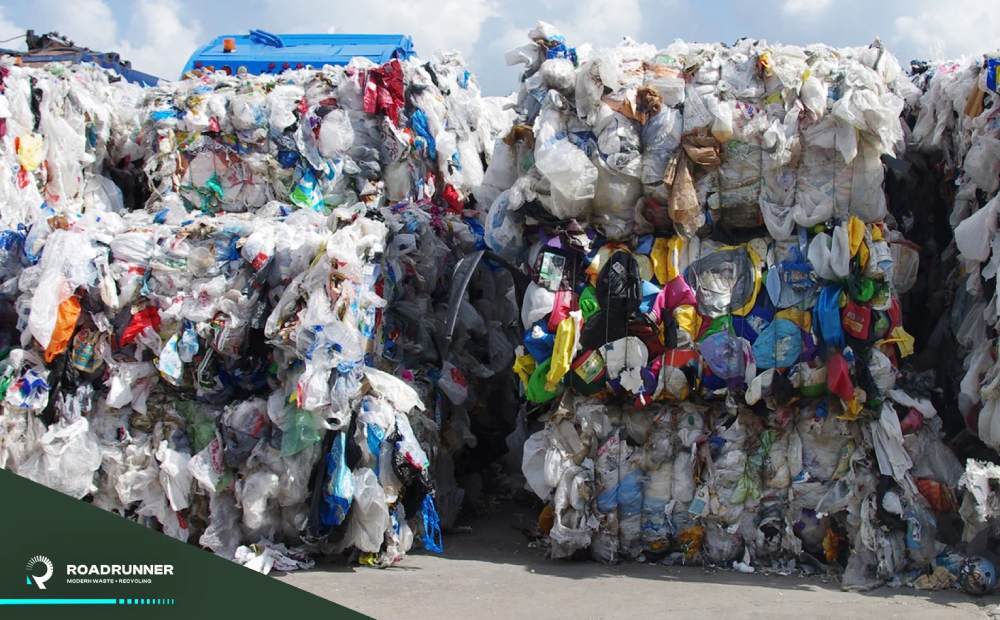 Compacted and baled recyclables sit outside, waiting for pickup.