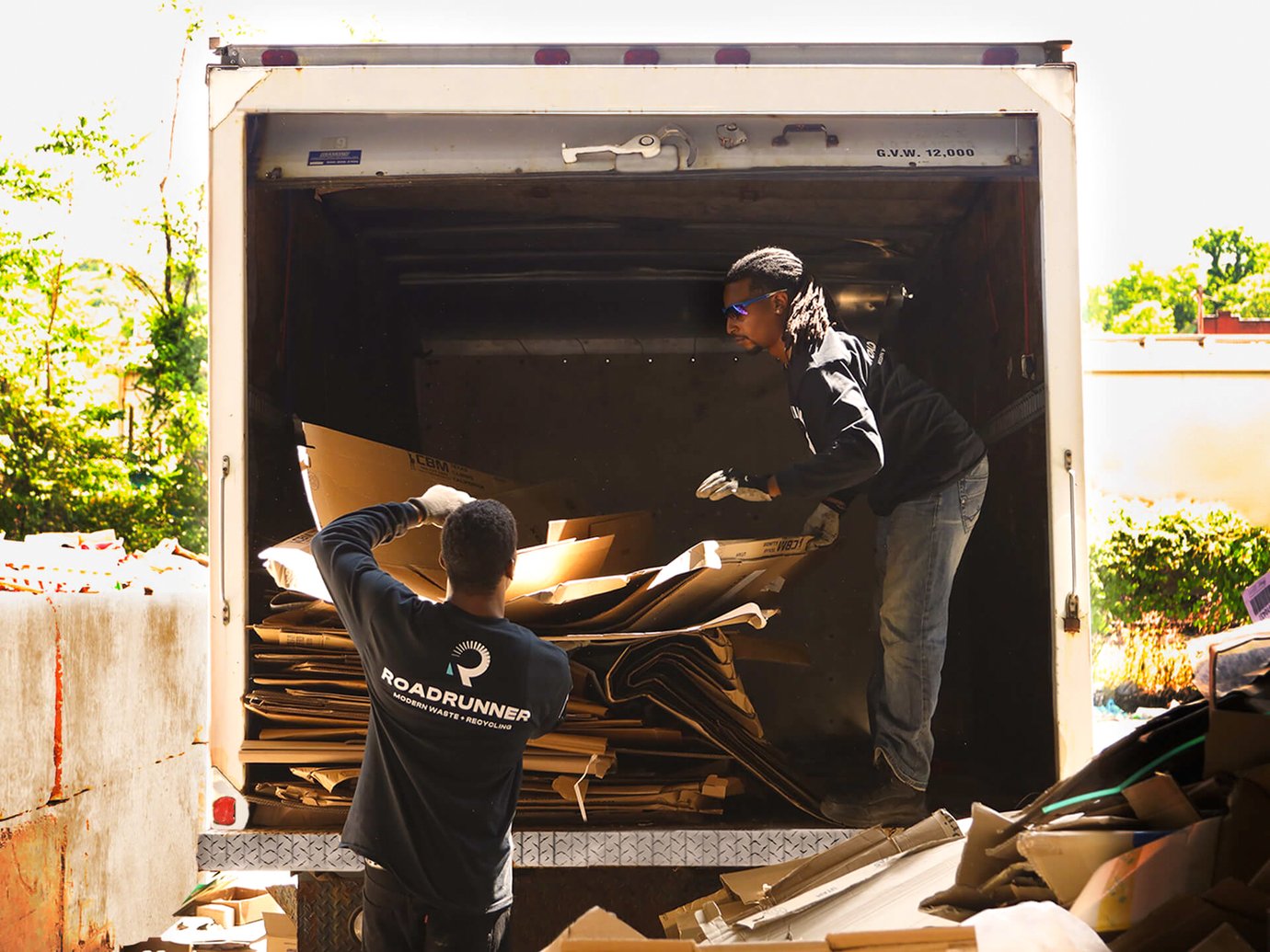 2 drivers dropping off cardboard at a recycling center