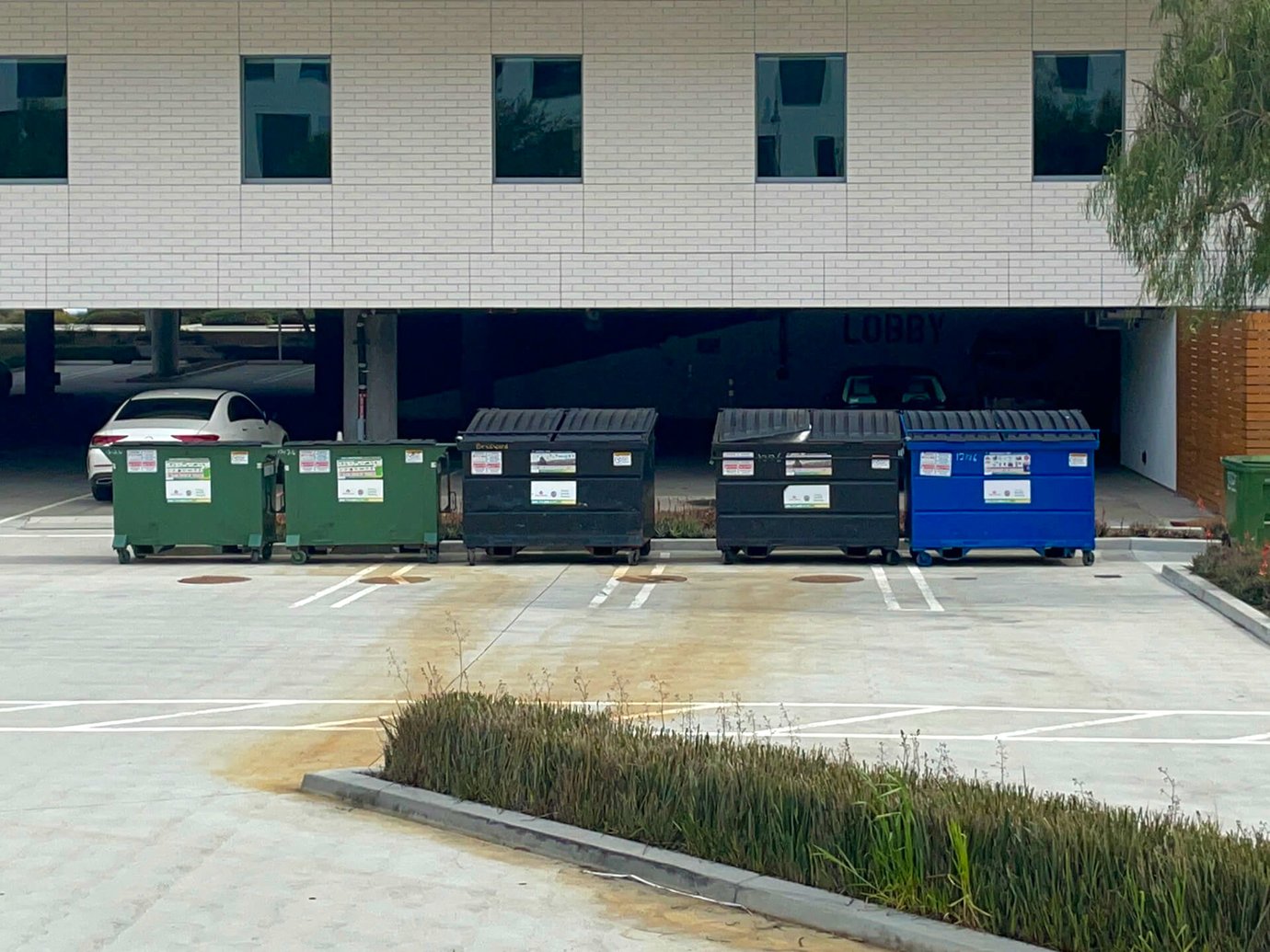 5 dumpsters outside of an office building