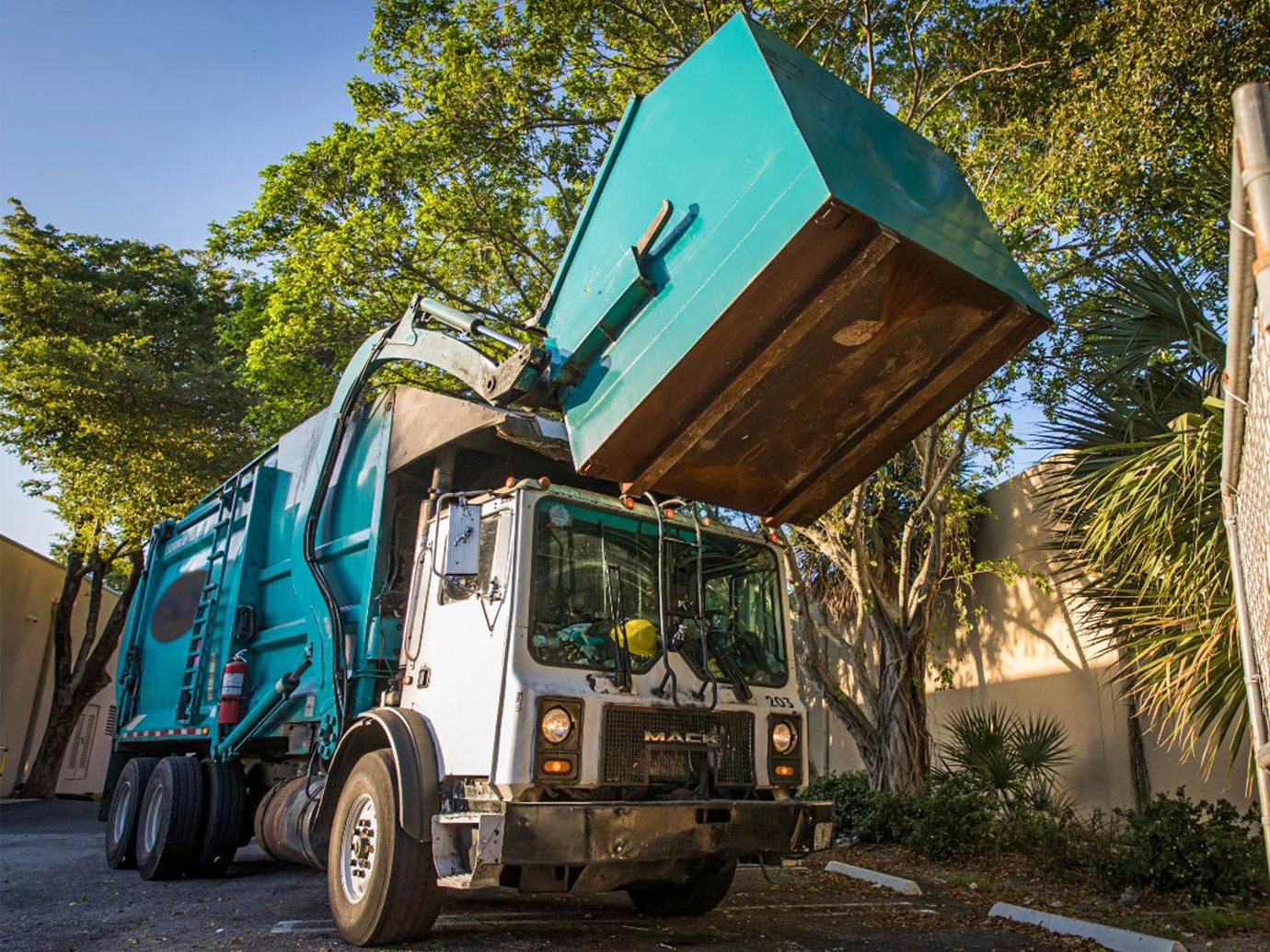 garbage truck picking up a dumpster