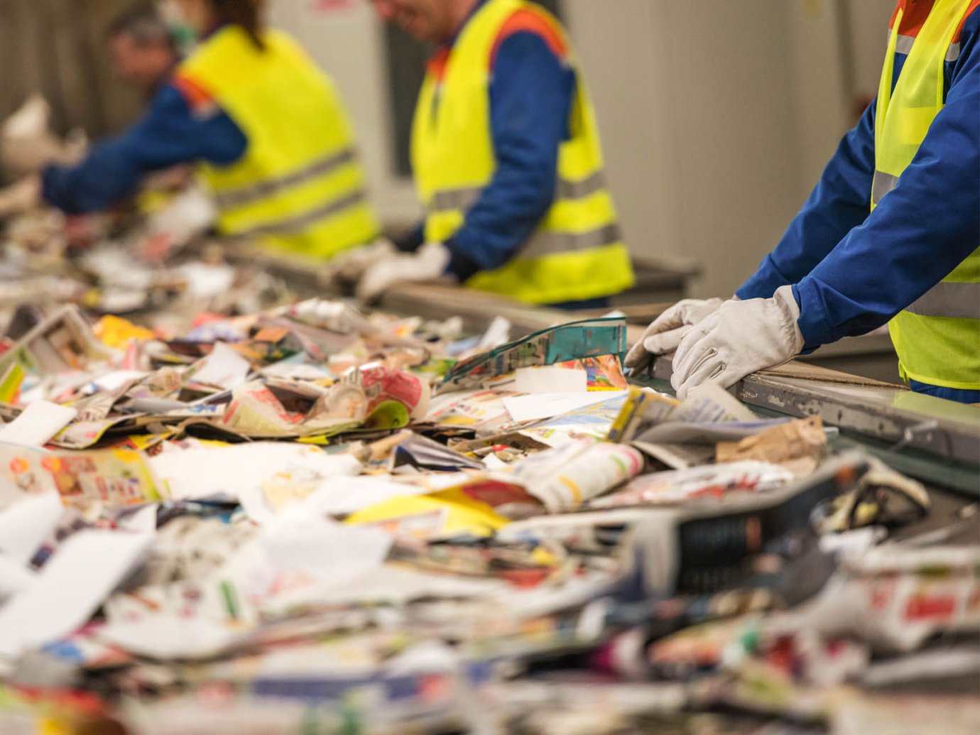 recycled paper being manually sorted on a conveyer belt