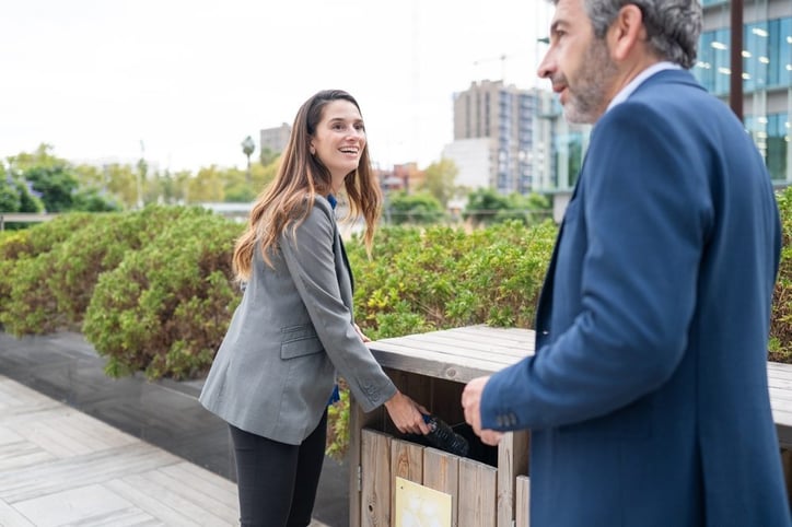 A businesswoman recycles at an office park.