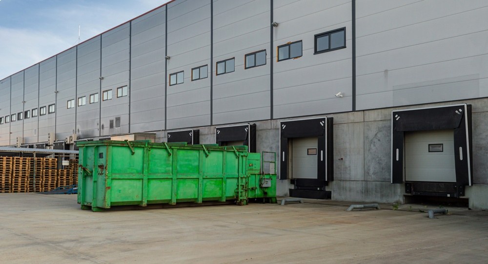 A large industrial warehouse with waste bins.
