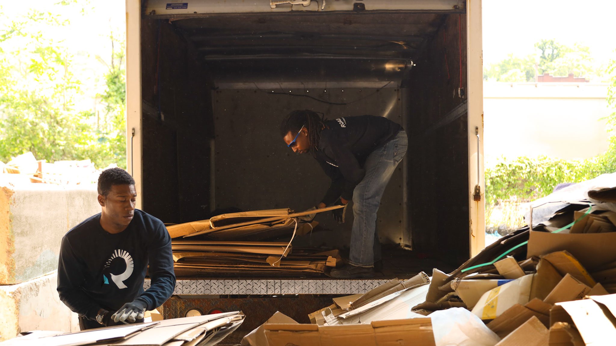 two box truck drivers dropping off non-contaminated cardboard at a recycling center